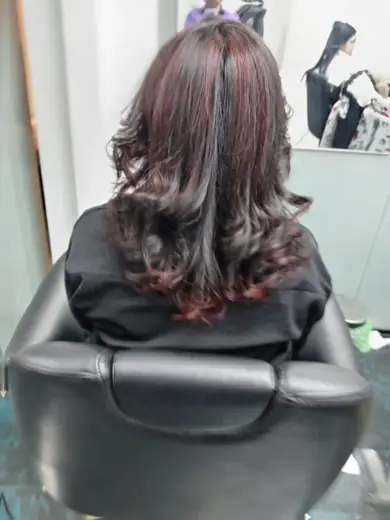Burgundy red highlights with soft curls done at Eternal Beauty Dubai