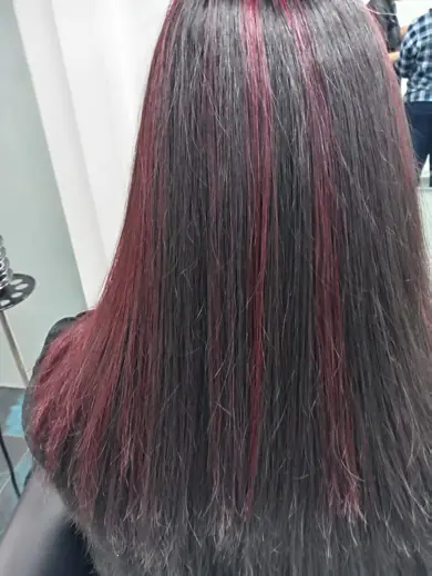 Long straight hair with red highlights coloured at Eternal Beauty Dubai